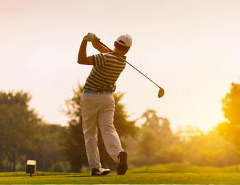 Golfer teeing up to hit a ball