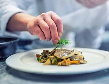 Chef putting the finishing touches on a dish at a fine dining restaurant