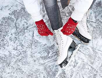 Young girl putting on her ice skates