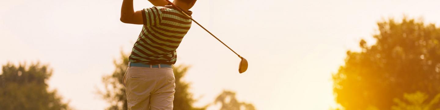 Golfer swinging his club on a golf course