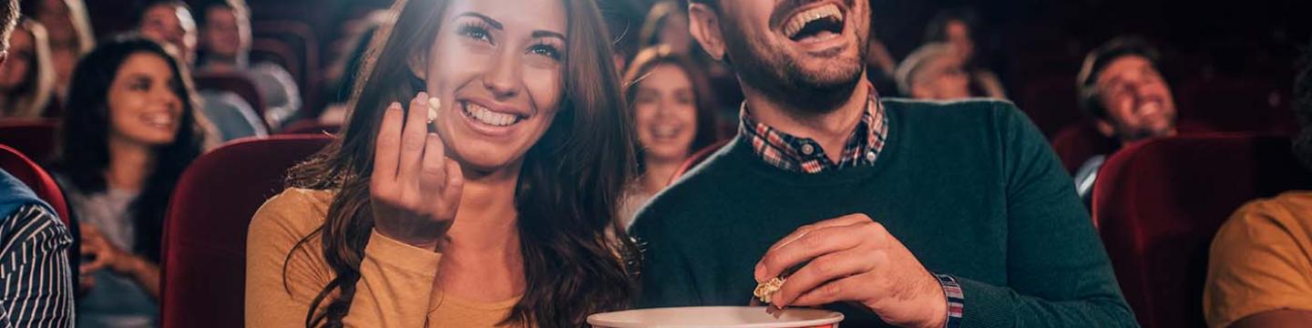 Couple enjoying popcorn together at the movie theatre