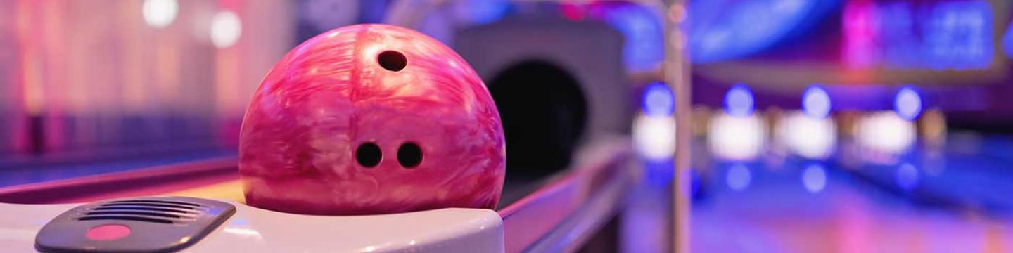 Pink bowling ball in bowling ball return at cosmic bowl in Mammoth