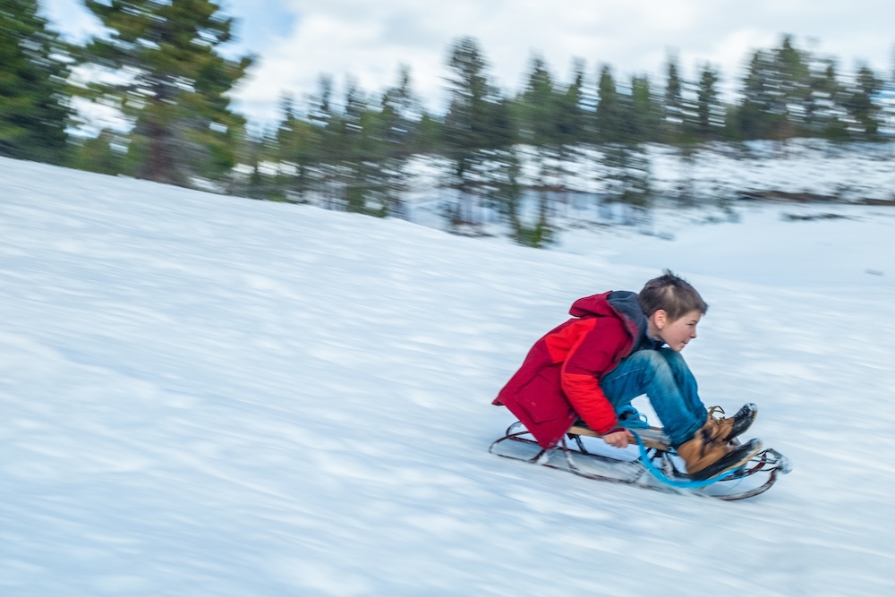 Boy Sledding Downhill Fast near Mammoth Lakes, California.