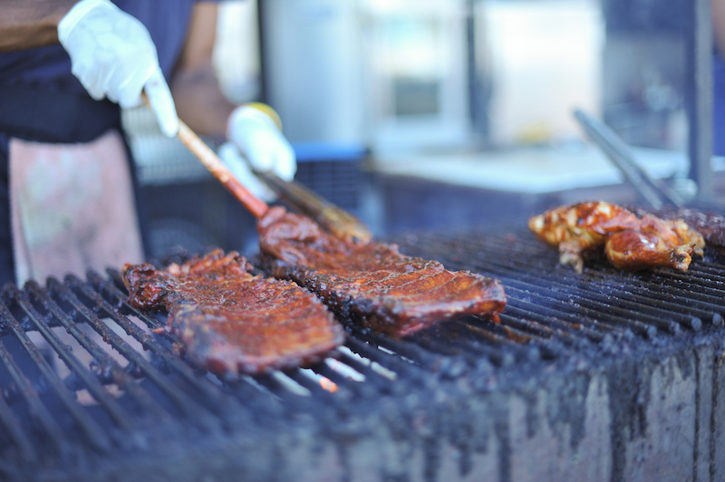 Man flipping ribs on a bbq grill